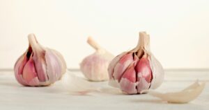 Whole garlic cloves and peeled garlic on a kitchen counter